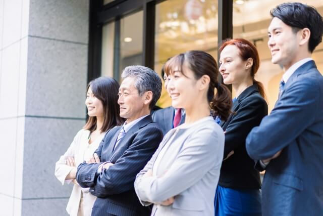 オフィス前で自信に満ちた社員たち